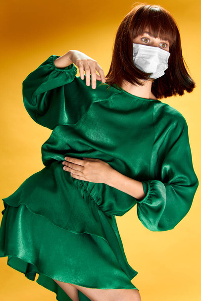 Woman in fashion dress posing in medical mask virus covid-19 - Foto, Bild