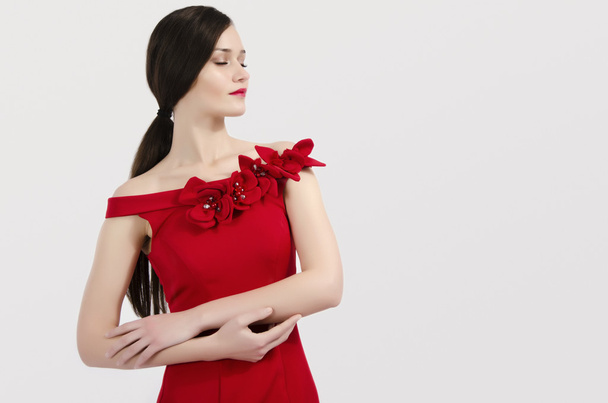 Beautiful brunette woman wearing an elegant red dress posing fashion. Profile of a woman - Foto, imagen