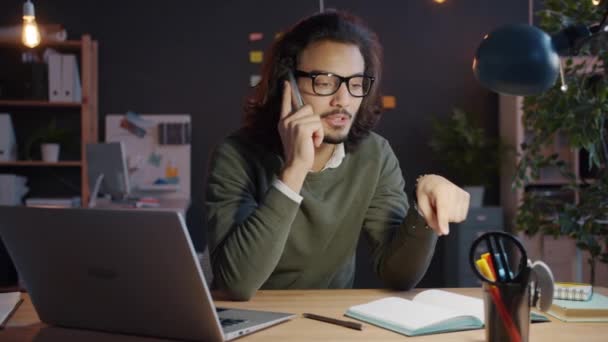Rallentatore dell'uomo arabo che fa telefonate mobili discutendo di lavoro in ufficio di notte - Filmati, video