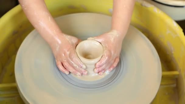The hands of a master potter help teach a child to create clay products in a pottery workshop. Art, craft - Footage, Video