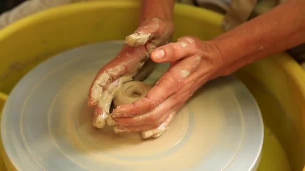 Les mains des femmes apprennent à créer des produits en argile sur une roue de potier. Artisanat, art - Séquence, vidéo