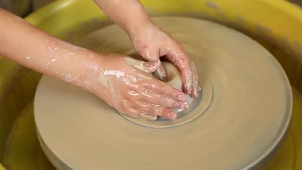 Ręce dzieci uczą się tworzyć wyroby gliniane na kole garncarskim. Masterclass dla dzieci w warsztacie garncarskim. Sztuki, rzemiosła - Materiał filmowy, wideo
