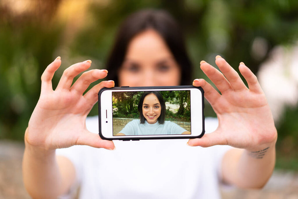 Young caucasian woman making a selfie at outdoors - Fotó, kép