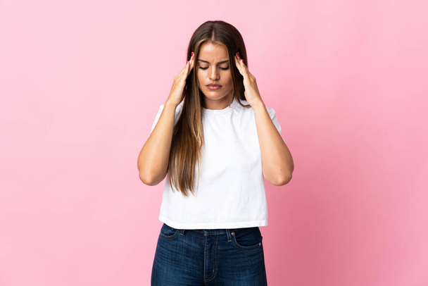 Young Uruguayan woman isolated on pink background with headache - Foto, Imagen