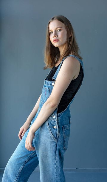 Junge attraktive Frau posiert in Jeans-Overalls  - Foto, Bild