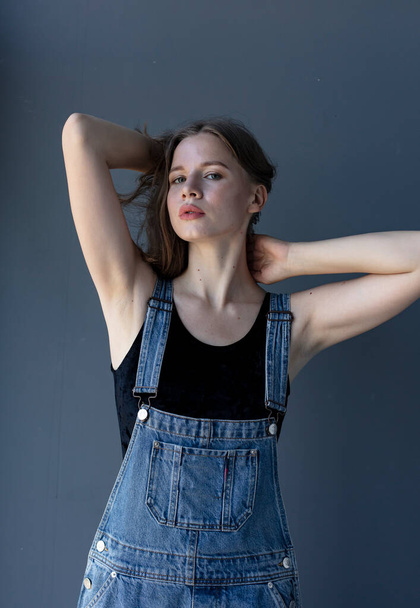 Young attractive woman posing in denim overalls  - Φωτογραφία, εικόνα