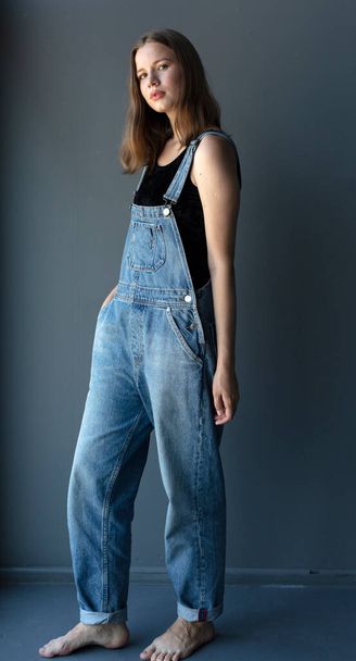 Young attractive woman posing in denim overalls  - Photo, Image