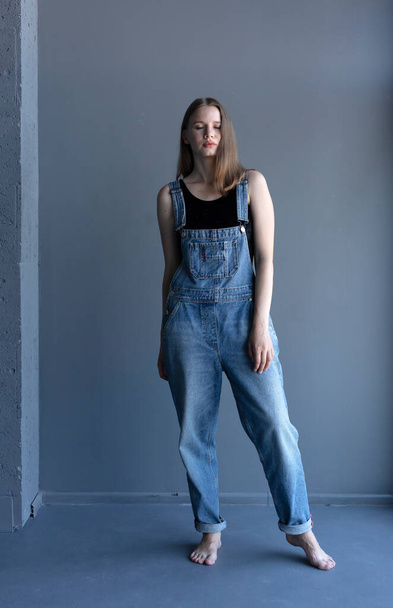 Young attractive woman posing in denim overalls  - Fotoğraf, Görsel