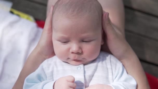 zbliżenie słodkie niemowlę chłopiec w mamy ramiona - Materiał filmowy, wideo