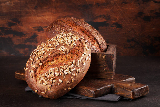 Різний домашній хліб з насінням. Перед дерев'яною стіною з копіювальним простором
 - Фото, зображення