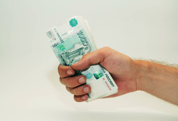 maschio mano detiene banconote di carta contanti di mille rubli - Foto, immagini