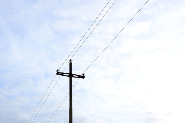 田舎の電力供給-電力線を持つ木製の電柱-絶縁され、明るい背景にさらされています - 写真・画像