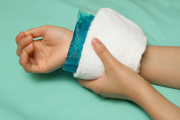 uma mulher aplicando o bloco frio no pulso dolorido inchado após o acci
 - Foto, Imagem