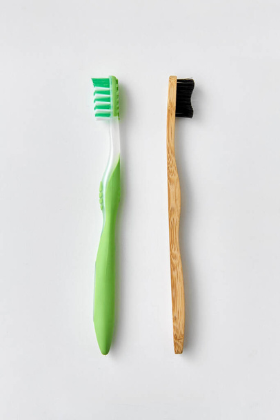 wooden and plastic toothbrush on white background - 写真・画像