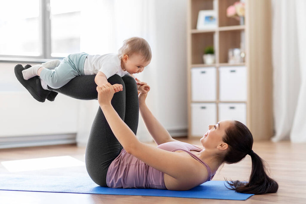 happy mother with little baby exercising at home - Photo, image