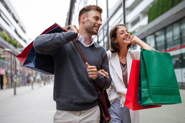 Happy young couple with shopping bags. Sale, travel, love consumerism and people concept. - Photo, Image