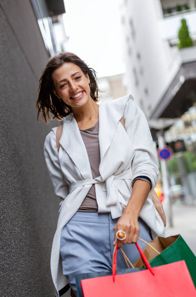 Happy woman with shopping bags enjoying in shopping. Consumerism, shopping, travel, lifestyle concept - Valokuva, kuva