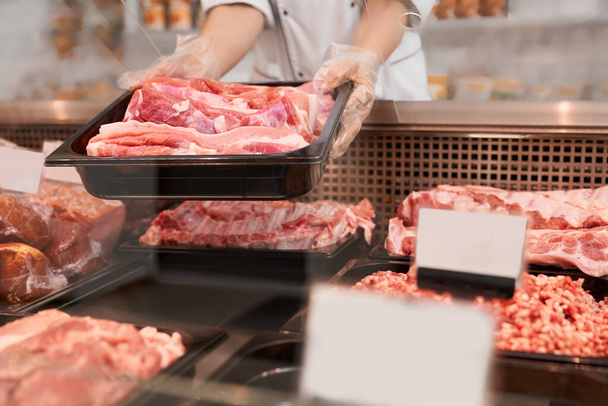 Raw meat in glass counter. - Foto, Bild
