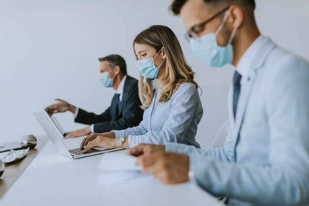 Grupo de empresários têm uma reunião e trabalhar no escritório e usar máscaras como proteção contra o vírus corona - Foto, Imagem