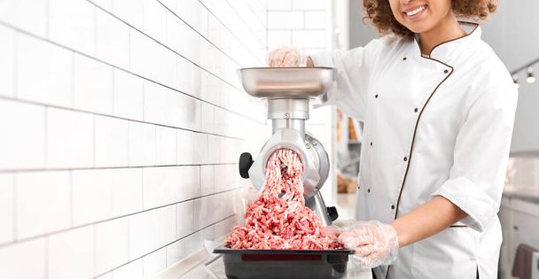 Incognito female butcher doing minced meat. - 写真・画像