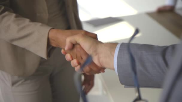 Бизнес-соглашение и успешная концепция переговоров, бизнесмен в костюме пожимает руку афроамериканке - Кадры, видео