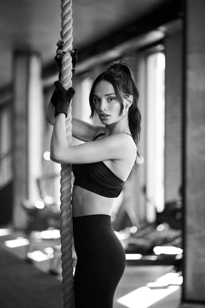 Fit woman posing in gym, monochrome. - Photo, Image