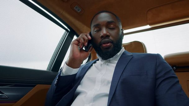 Iloinen afrikkalainen mies soittaa puhelimeen. Afro liikemies hymyilee ajoneuvolle. - Valokuva, kuva