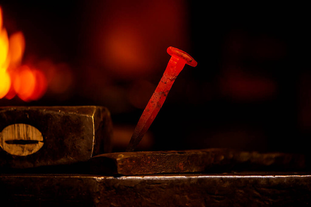 Крупный план горячий металлический гвоздь на наковальню в кузнечной мастерской
  - Фото, изображение