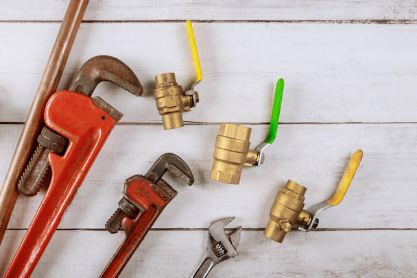 Brass gate valve on wooden background, monkey wrench brass plumbing fittings - Foto, imagen