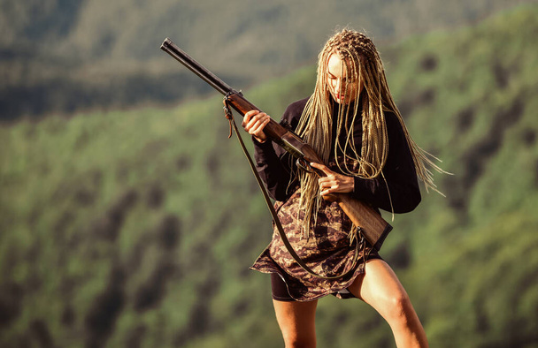 Hunting season. Sexy warrior. She is warrior. Woman attractive long hair pretty face hold rifle for hunting. Dangerous girl. Defending concept. Warrior mountains landscape background. Feminist girl - Foto, imagen