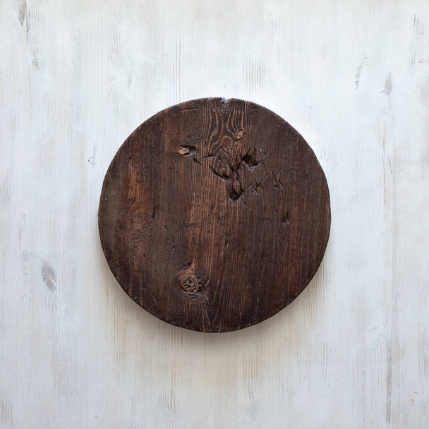 grunge άδειο στρογγυλό ξύλινο πιάτο σε παλιό ξύλινο τραπέζι, φόντο με copyspace - Φωτογραφία, εικόνα