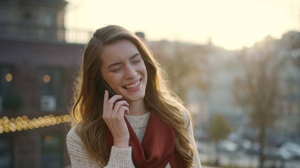 屋外で携帯電話を話す甘い女性。路上で携帯電話を使用して幸せな女の子. - 写真・画像