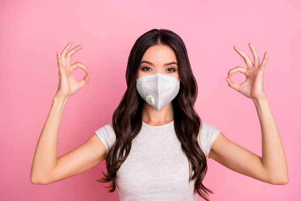 Close-up portrait of her she nice-looking attractive pretty wavy-haired girl wearing safety n95 respirator mask showing double ok-sign stop mers cov pandemia isolated over pink pastel color background - Фото, изображение
