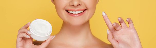 cropped view of smiling naked beautiful woman with cosmetic cream on finger isolated on yellow, panoramic shot - Fotoğraf, Görsel