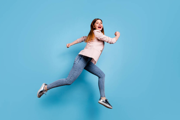 Full body profile side photo of cheerful girl jump run fast after spring season discounts wear checkered outfit gumshoes isolated over blue color background - Foto, afbeelding