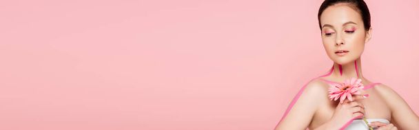 schöne Frau mit rosa Linien auf dem Körper und Chrysanthemen isoliert auf rosa, Panoramaaufnahme - Foto, Bild