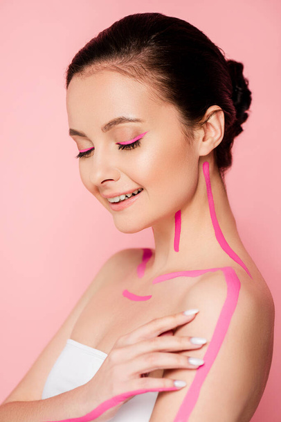 smiling beautiful woman with pink lines on body isolated on pink - Foto, Imagen