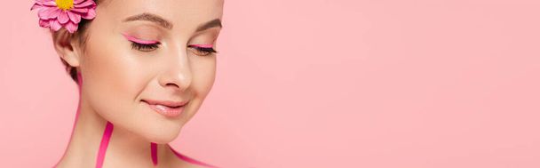 smiling beautiful woman with pink lines on body and flower isolated on pink, panoramic shot - Foto, afbeelding
