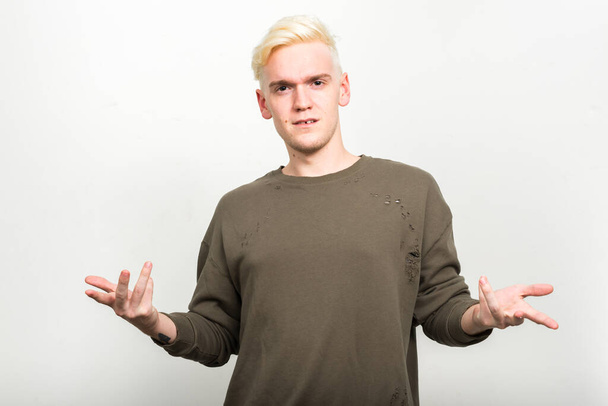 Studio shot of young man with blond hair against white background - Fotoğraf, Görsel