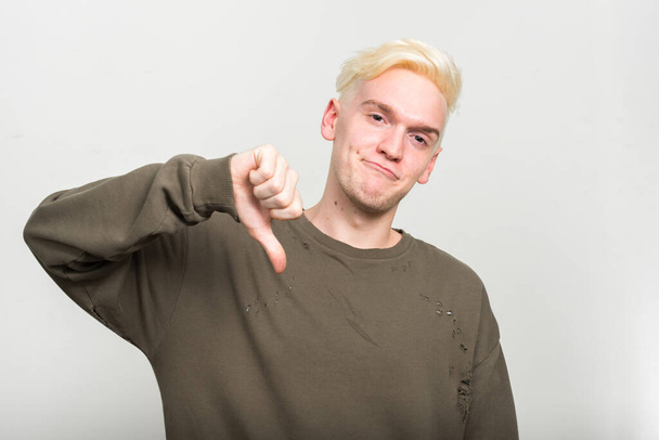 Studio shot of young man with blond hair against white background - Фото, изображение