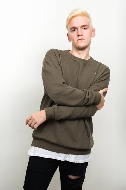 Studio shot of young man with blond hair against white background - Fotoğraf, Görsel