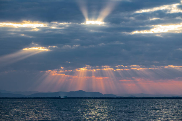 Хмарочос на заході сонця над озером Малаві з променями сонця. - Фото, зображення