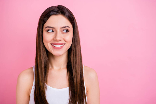 Closeup photo of cute attractive lady good mood beaming smile long perfect hairdo look side empty space wear casual white singlet isolated pastel pink color background - Фото, изображение