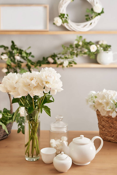 Ünnepi asztalterítés. Teáskészlet és virágok az asztalon. Rózsa és bazsarózsa csokor. Anyák napi üdvözlőlap. Boldog szülinapot! Ünnepi asztal virágokkal. Esküvői meghívók és dekorációk. - Fotó, kép