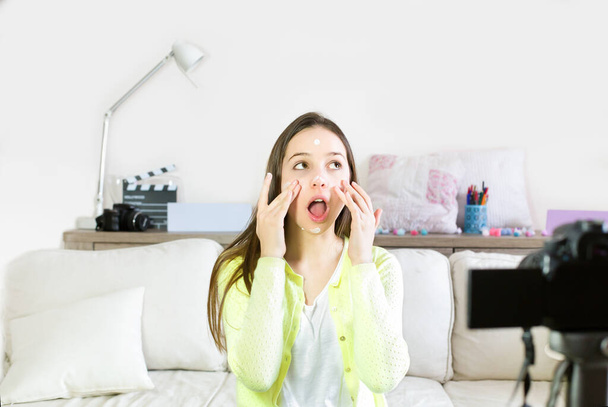 Nastoletnia dziewczyna blogger cute prezentując kosmetyki kosmetyczne i nadawanie na żywo wideo do sieci społecznościowych. Skup się na wpływowej nastolatce. Piękno blogger i vlog koncepcja. - Zdjęcie, obraz