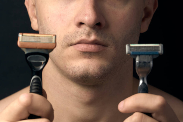 Großaufnahme eines männlichen Kinns. Rasiermesser für das Gesicht in der Hand. - Foto, Bild