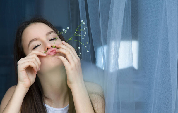 Πορτρέτο της όμορφης έφηβης που διασκεδάζει με λουλούδια γυψόφυλλης - Φωτογραφία, εικόνα