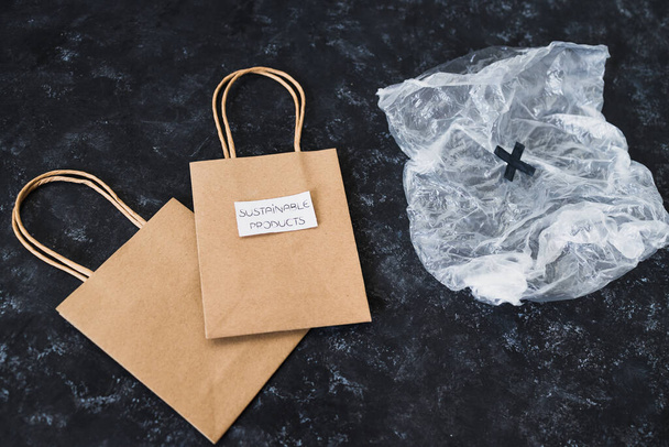 ecological choices and environmental awareness concept, Sustainable Products label on reusable bags next to plastic bag - Fotoğraf, Görsel