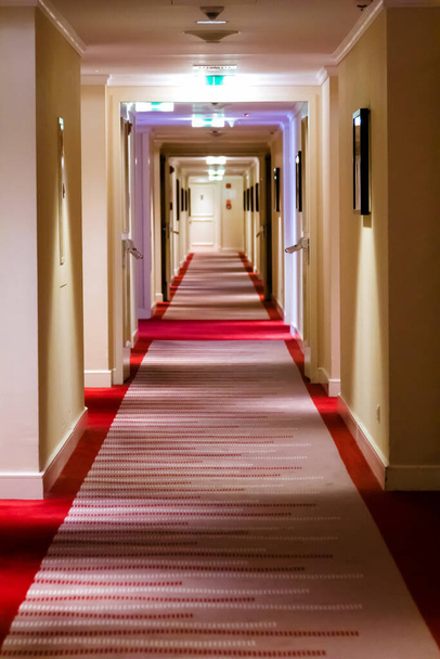 Modern hotel corridor with red brown capet to exit stairway. - Photo, Image