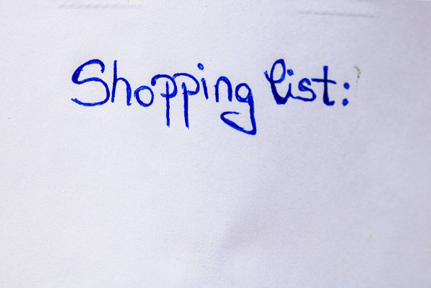 Shopping list handwriting text close up isolated on white paper with copy space. Writing text on memo post reminder - Photo, Image
